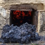 Große Schlackenklötze bildeten sich bei beiden Verhüttungsvorgängen am Übergang zwischen Schürkanal und Kuppel und konnten ohne den Schürkanal zu beschädigen geborgen werden (Foto: LWL-Freilichtmuseum Hagen/Fenja Reuter). (vergrößerte Bildansicht wird geöffnet)
