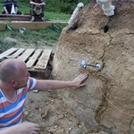 Wenige Risse in der Ofenwandung werden mit Lehm verpresst. (vergrößerte Bildansicht wird geöffnet)