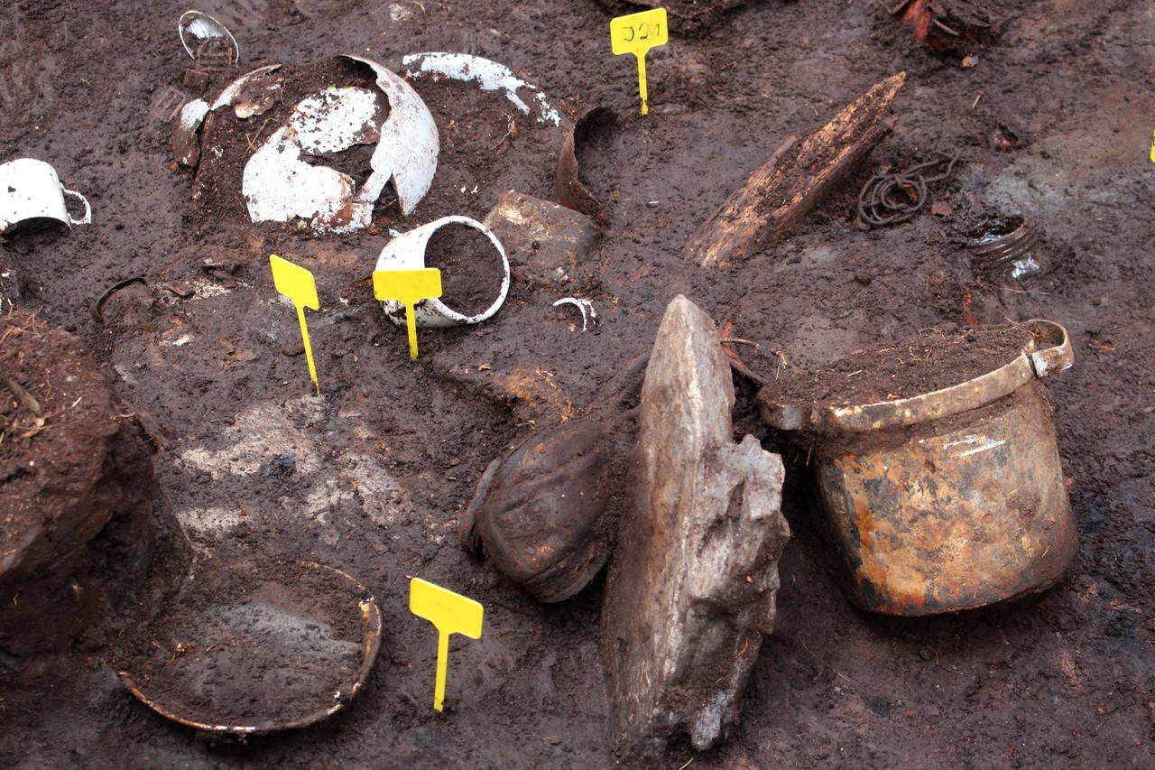 Erschießungstatort Warstein, Langenbachtal: Ausschnitt der Grabung mit einer Vielzahl teilfreigelegter Fundobjekte der Opfer (Foto: LWL-Archäologie für Westfalen/Manuel Zeiler).