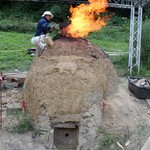 Erica Hanning vom Römisch-Germanischen Zentralmuseum füllt Erz in den Ofen (vergrößerte Bildansicht wird geöffnet)