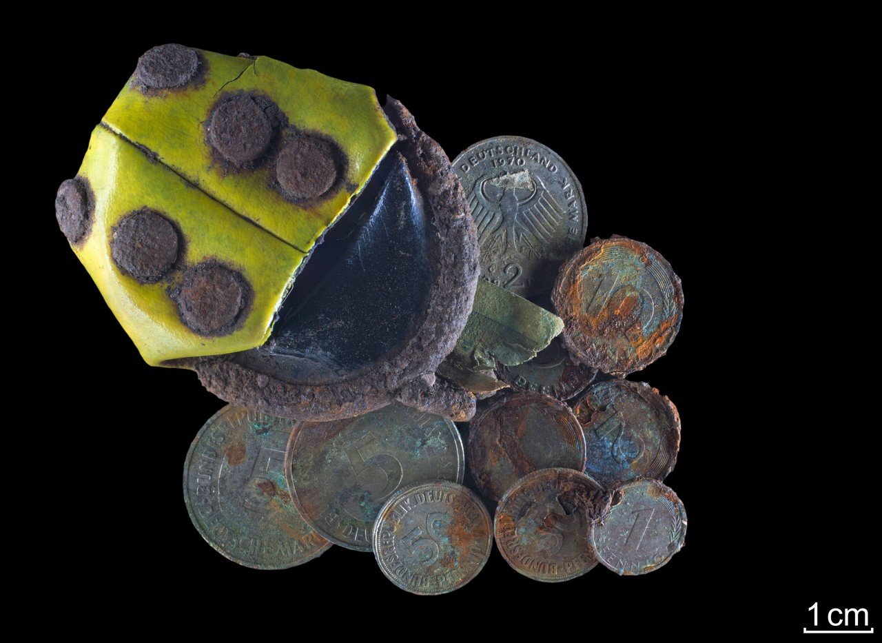 Marienkäferportemonnaie samt Inhalt. Der kleine Fetzen in der Mitte ist Teil der Überreste des Geldscheins (Foto: LWL-Archäologie für Westfalen/T. Poggel).