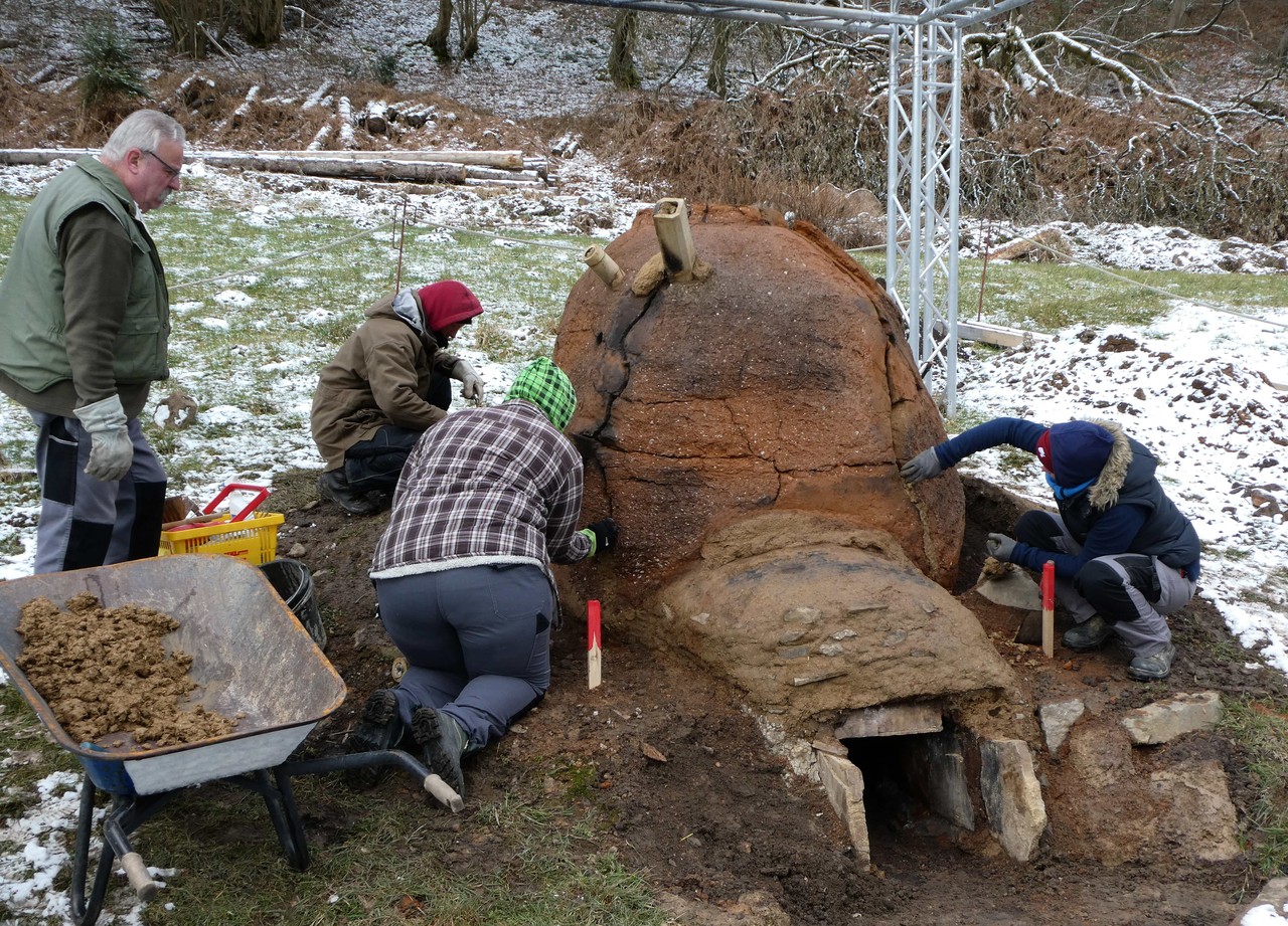 Das Team der Forschungskooperation beim Bauen eines Schutzmantels um den Rennofen (Foto: LWL-Archäologie für Westfalen/M. Zeiler).