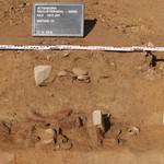 Dicht gepackter Grubenboden aus Steinen und großen Keramikscherben. - Foto: M. Baales/LWL-AfW Olpe. (vergrößerte Bildansicht wird geöffnet)
