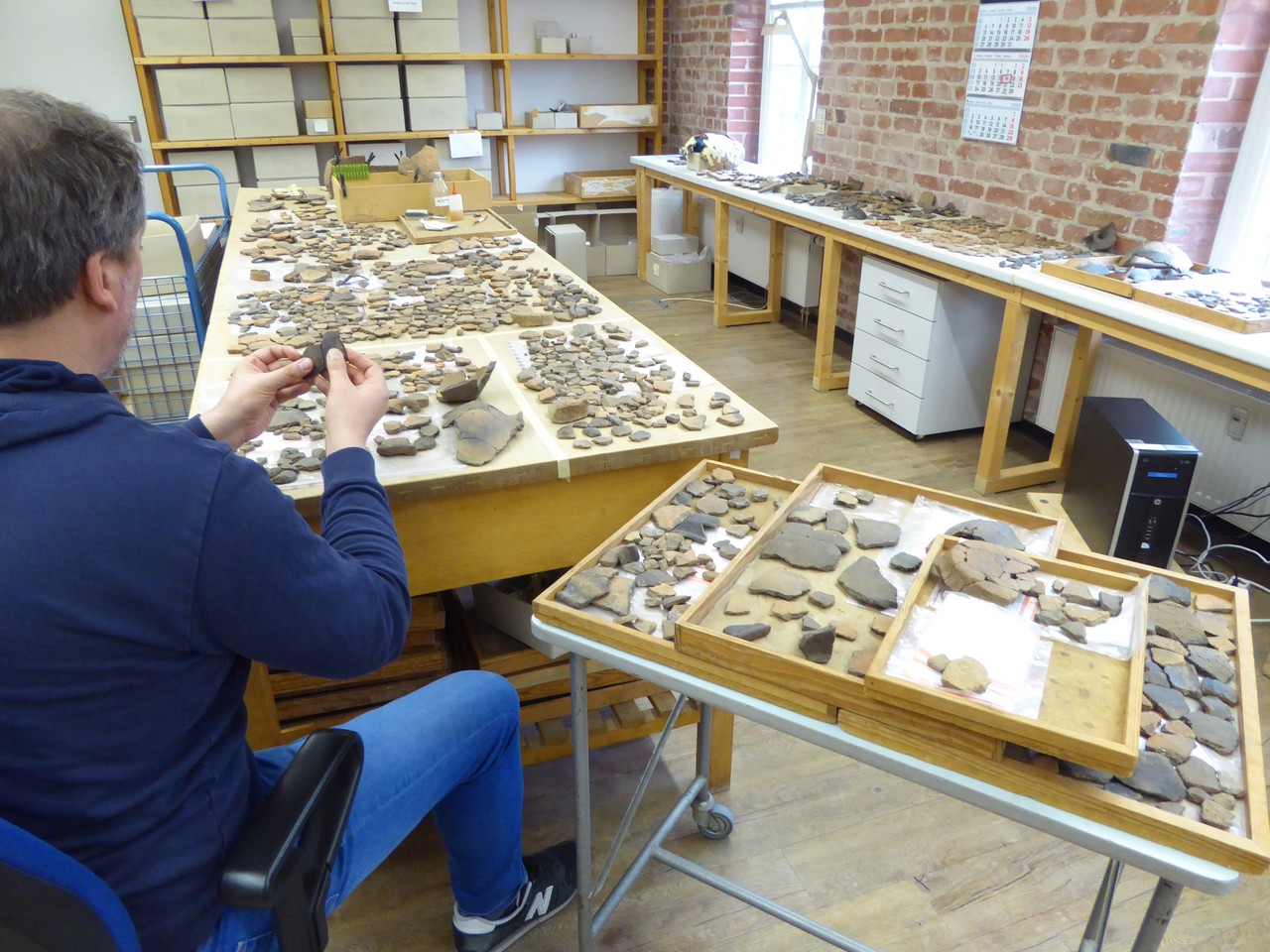 in einsamer Mitarbeiter und viele Scherben: Für die Puzzlearbeit ist Ruhe und Konzentration nötig; Foto:LWL/S.Spiong