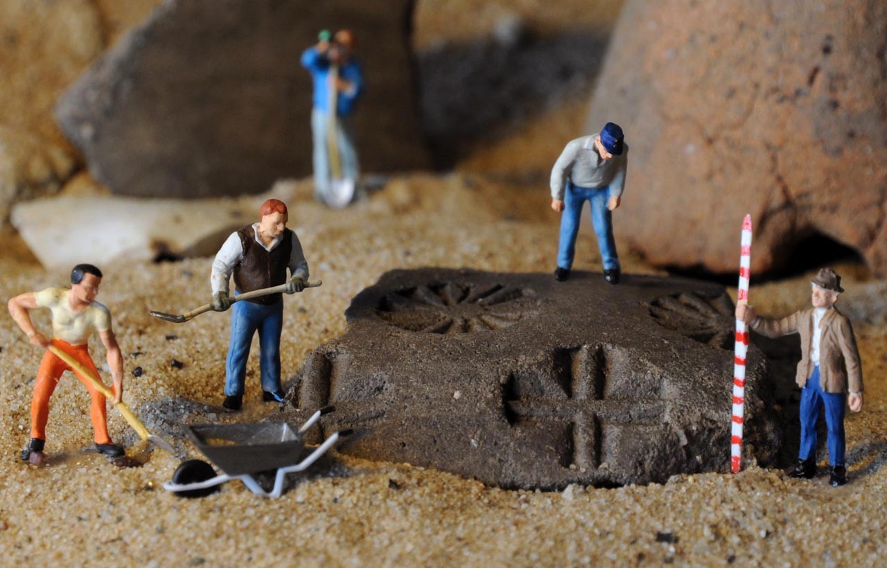 Stempelverzierte Scherbe in Ausgrabungsszene mit kleinen Figuren; Foto: LWL/C.Hildebrand