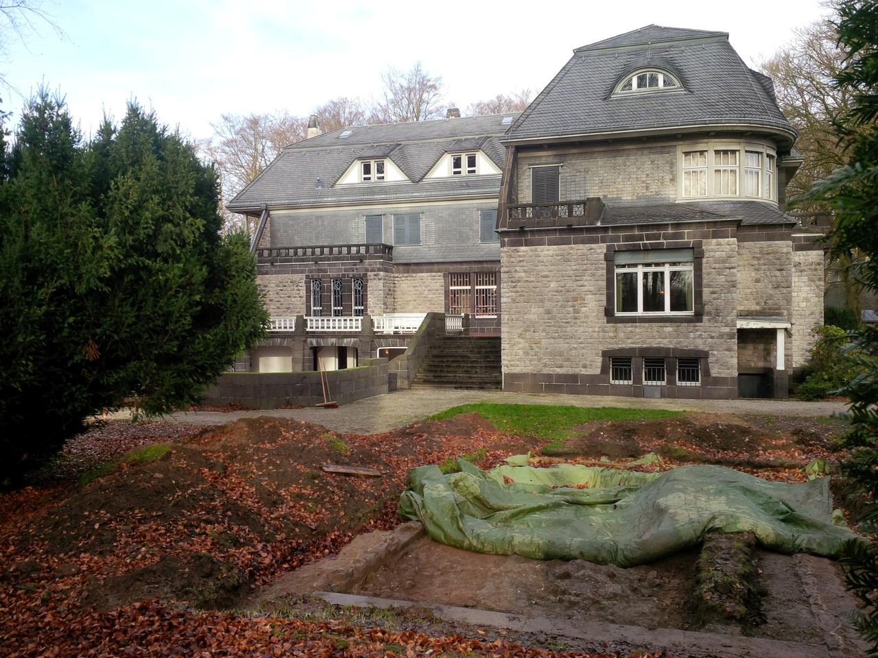 Hagen, Hohenhof. Blick aus dem Garten auf die Villa. Im Vordergrund das 2019 freigelegte Fundament, das auf den Gartenplänen in dieser Form nicht verzeichnet ist. – Foto: LWL-AfW Olpe/M. Baales.