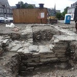 Die Basis der Nordmauer mit der ansetzenden Gruft war aus Lagen größerer und kleinerer Schieferplatten mit Mörtel errichtet worden. – Foto: LWL-AfW Olpe/M. Baales. (vergrößerte Bildansicht wird geöffnet)