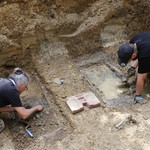 Warstein-Melkeplätzchen. Freilegungsarbeiten an zwei provisorischen Holztragen, mit denen die Ermordeten im Mai 1945 aus dem Langenbachtal zum Friedhof gebracht worden waren. – Foto: LWL-AfW Olpe/Kevin Sina. (vergrößerte Bildansicht wird geöffnet)